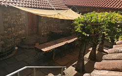 Courtyard viewed from above with large table and sail offering shade
